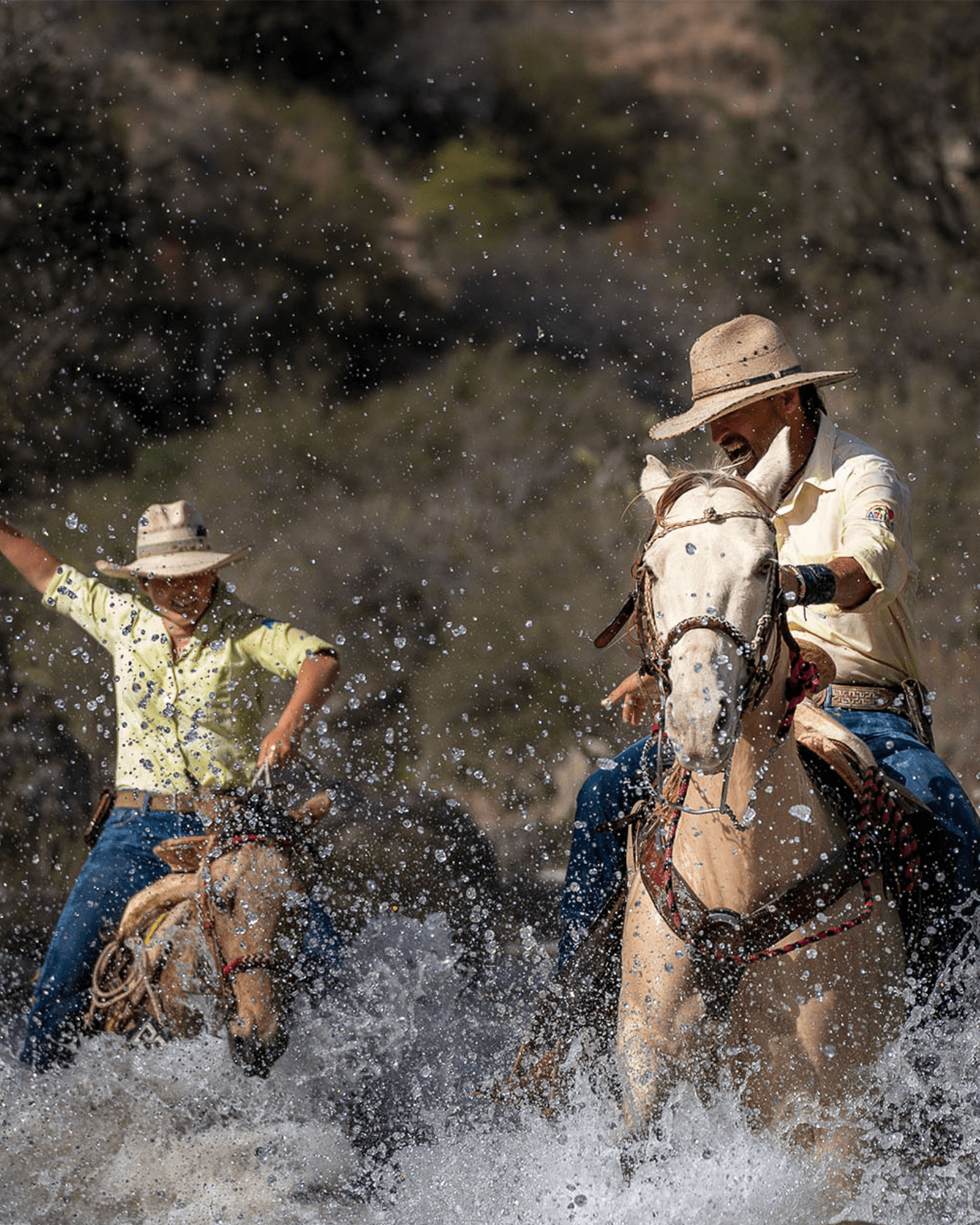 Horseback riders splashing through a river outside San Miguel