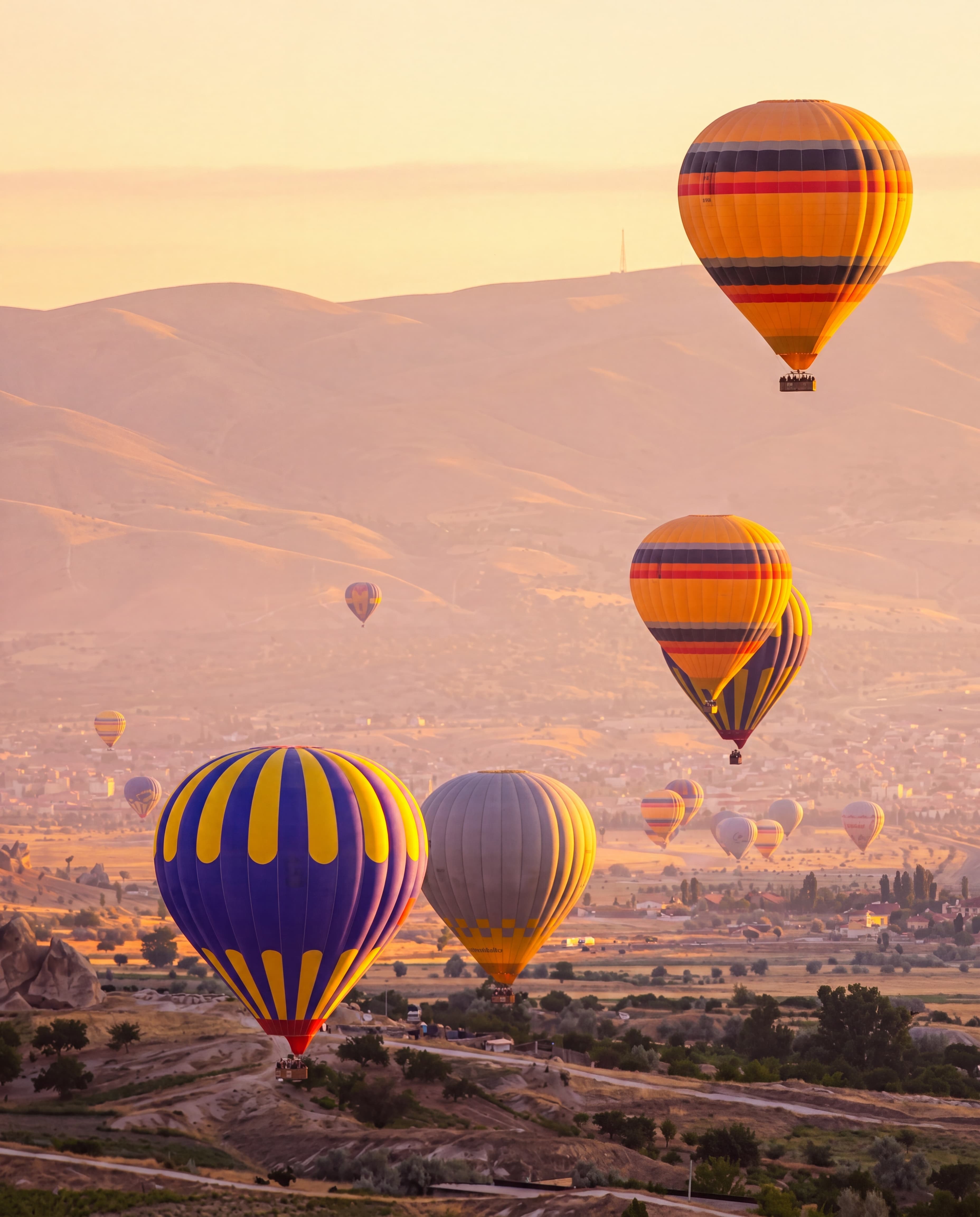 Hot air balloons drifting over the high desert at sunrise